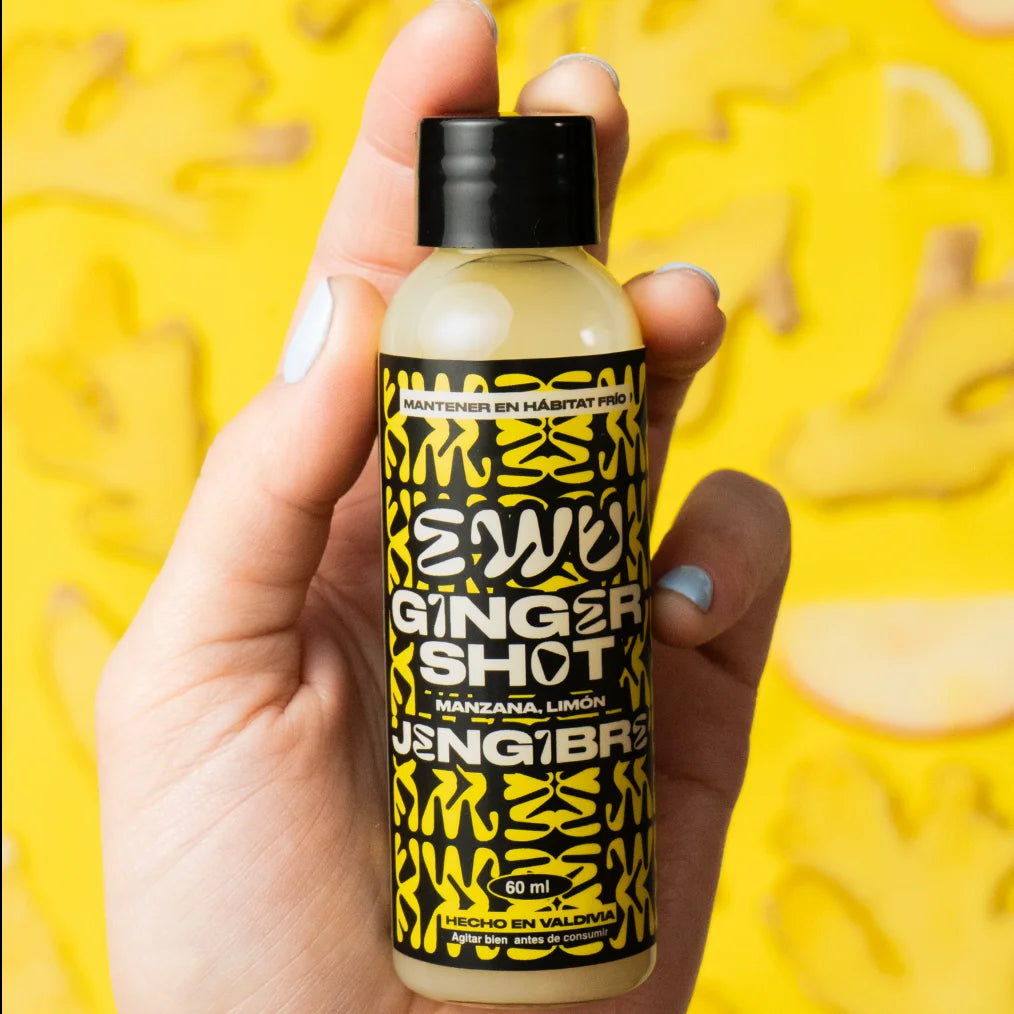 Mano sosteniendo una botella de EWU Ginger Shot Jengibre